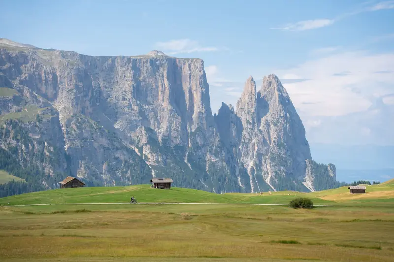 Holzhütten auf den Wiesen der Seiser Alm vor dem Schlern